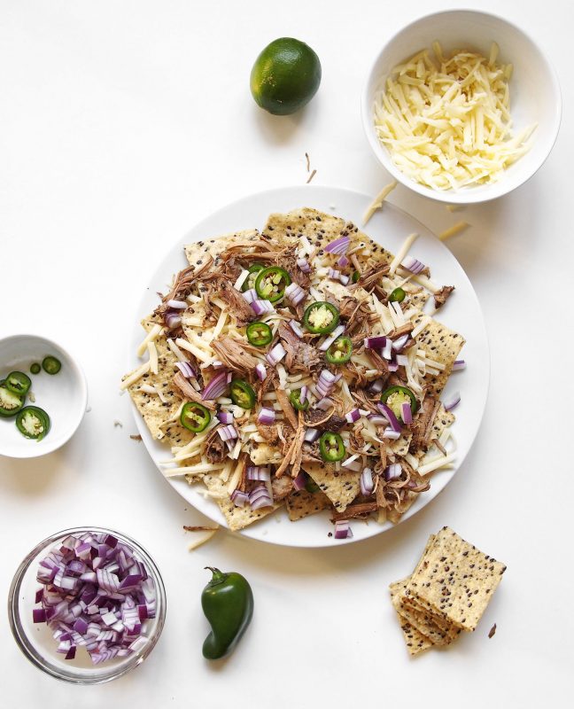 Slow roasted chili lime pork shoulder makes for a way better plate of nachos in this recipe.